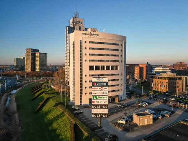Kantoorgebouw Eclipse Building aan het Rivium Quadrant in Capelle aan den IJssel, omringd door andere kantoorpanden en een parkeerterrein.